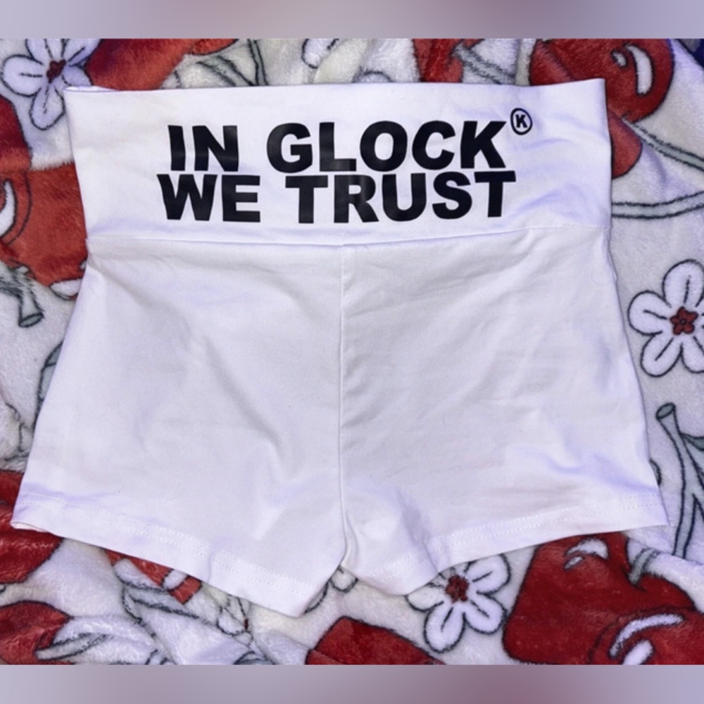 y2k white mini shorts that say “in glock we trust” on the back